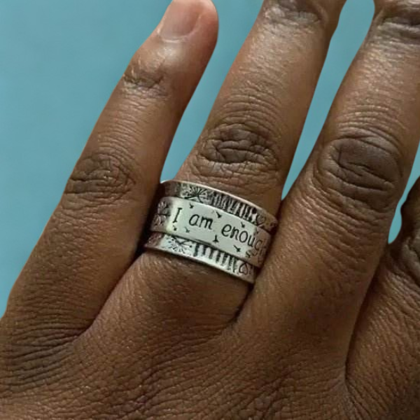 I Am Enough silver ring displayed on a hand, featuring an elegant design with motivational inscription